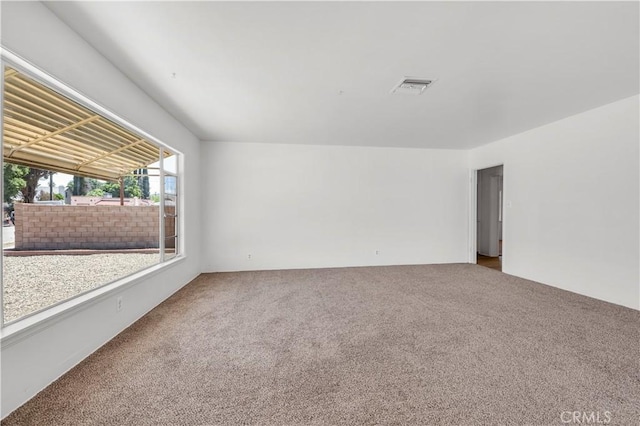 carpeted empty room featuring visible vents