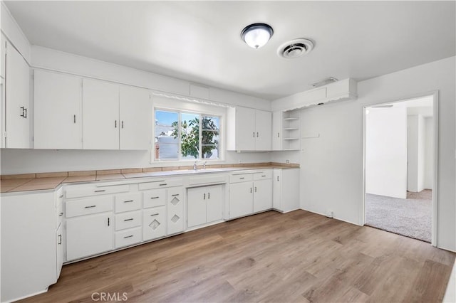 kitchen featuring light countertops, white cabinets, open shelves, and light wood finished floors