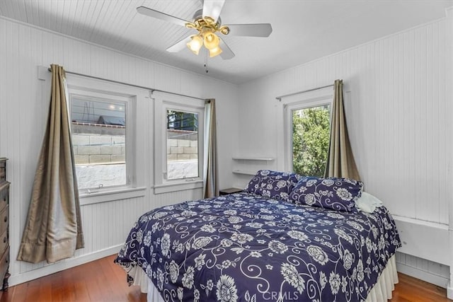 117 Maiden Ln, Avalon, CA 90704 - bedroom featuring wooden walls, a ceiling fan, and wood finished floors