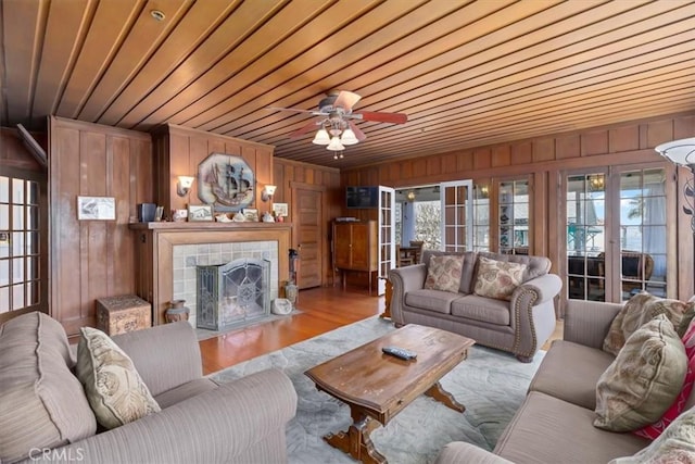117 Maiden Ln, Avalon, CA 90704 - living area featuring ceiling fan, a fireplace, wood walls, wooden ceiling, and wood finished floors