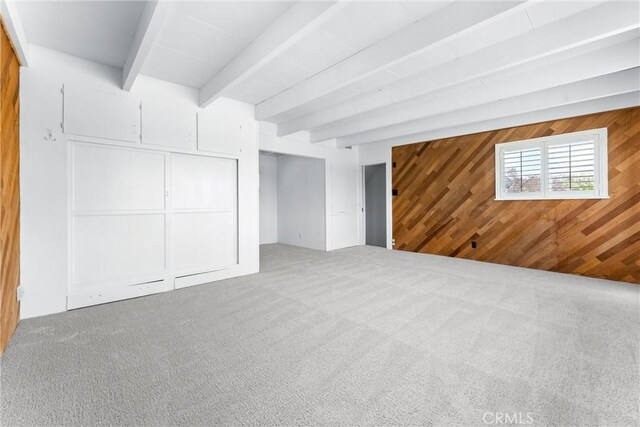 interior space with beamed ceiling and wood walls