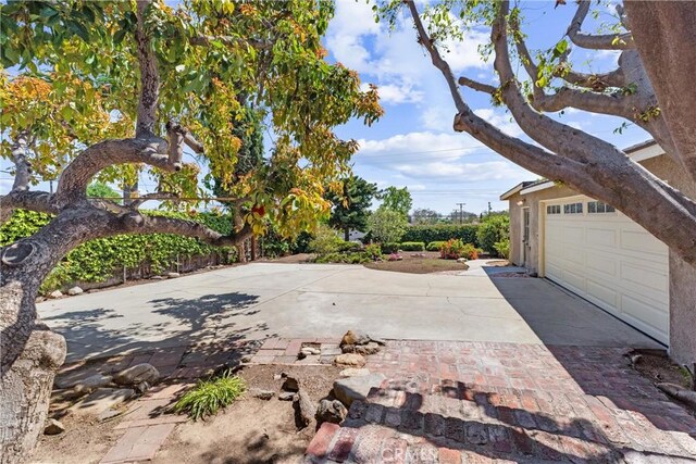 view of patio featuring an attached garage and decorative driveway