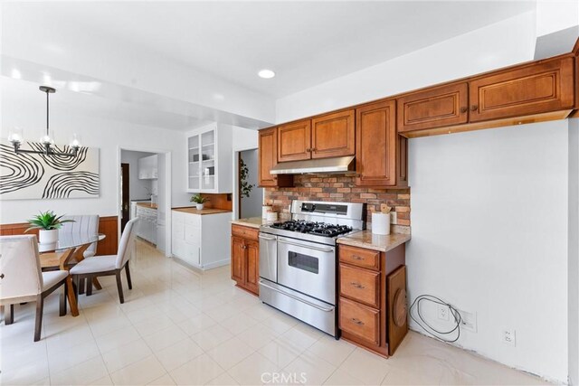 kitchen with under cabinet range hood, a chandelier, double oven range, and brown cabinets