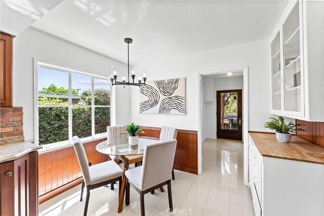 dining area with light tile patterned floors, a chandelier, and a wealth of natural light