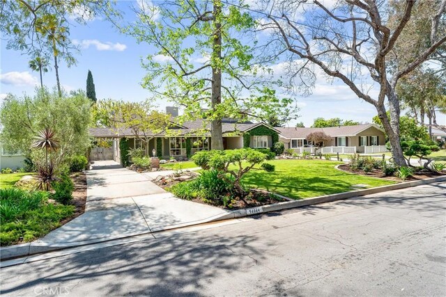 ranch-style home with a front yard and concrete driveway
