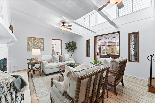 living room featuring a ceiling fan, high vaulted ceiling, baseboards, and light wood-style floors