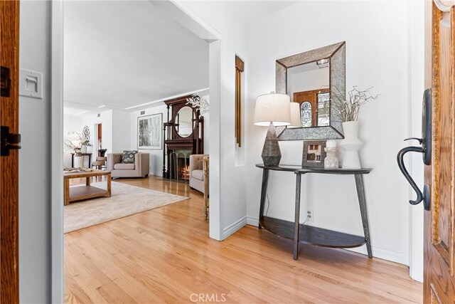 hallway featuring baseboards and light wood-type flooring