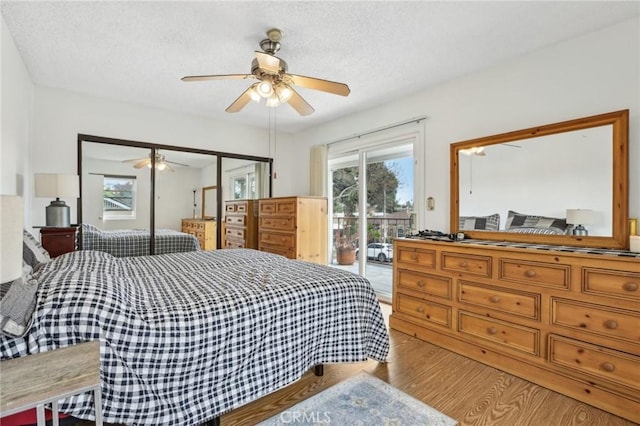 bedroom with a ceiling fan, light wood-type flooring, a textured ceiling, and access to exterior