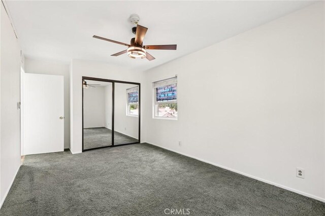unfurnished bedroom with carpet floors, baseboards, and a closet