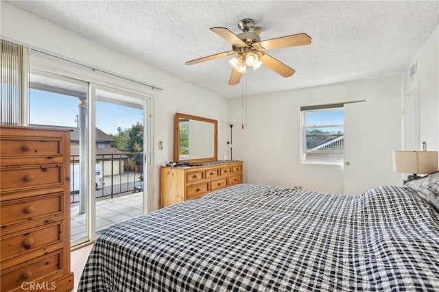 bedroom with visible vents, a textured ceiling, ceiling fan, and access to exterior