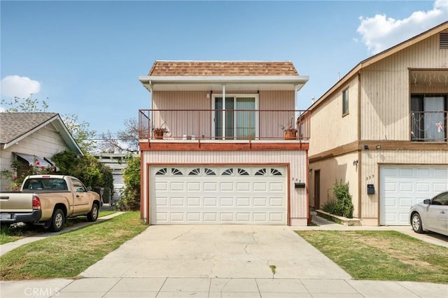 traditional home with concrete driveway, a balcony, roof with shingles, and a garage