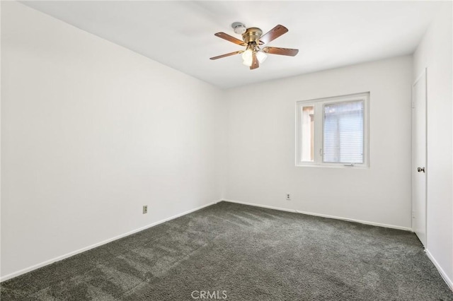 empty room featuring baseboards, ceiling fan, and dark carpet