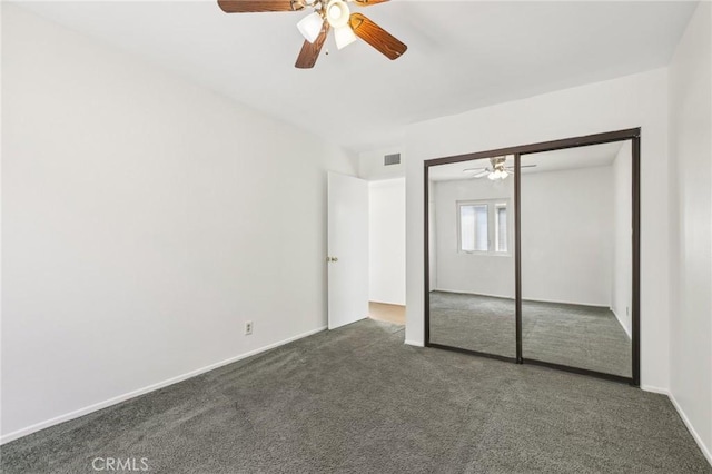 unfurnished bedroom with ceiling fan, dark carpet, baseboards, visible vents, and a closet