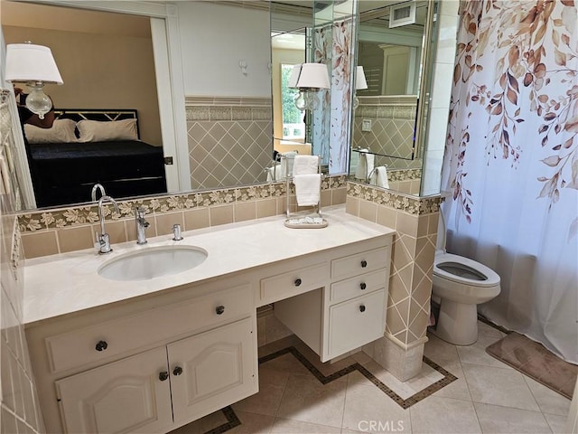 full bathroom featuring vanity, tile patterned floors, toilet, and tile walls