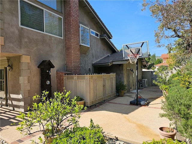 view of home's exterior featuring a gate, stucco siding, and fence