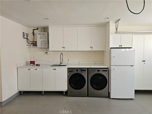 washroom featuring washing machine and clothes dryer, cabinet space, a sink, recessed lighting, and baseboards