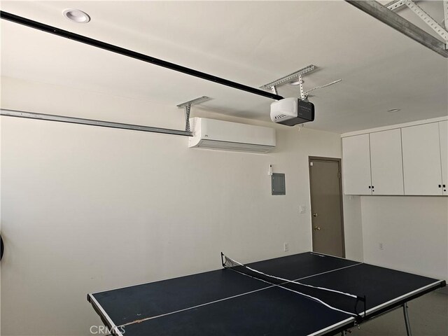 playroom featuring electric panel, an AC wall unit, and a garage
