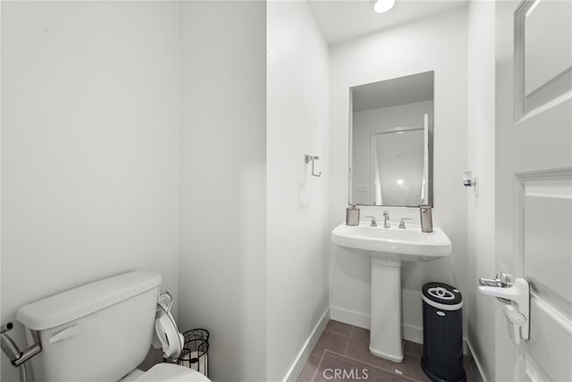 bathroom featuring toilet, tile patterned floors, and baseboards