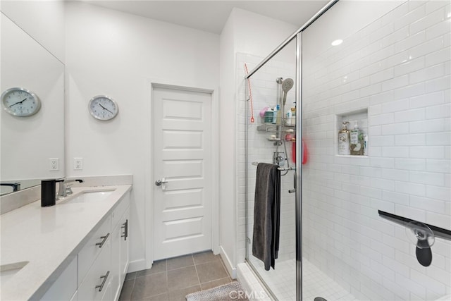 full bathroom with a sink, tile patterned flooring, a stall shower, and double vanity