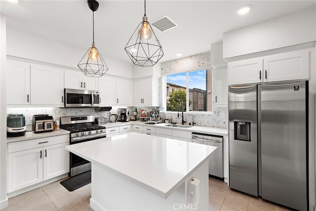kitchen featuring appliances with stainless steel finishes, a sink, light countertops, backsplash, and visible vents
