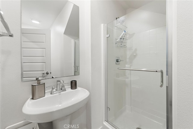 bathroom with a sink and a stall shower