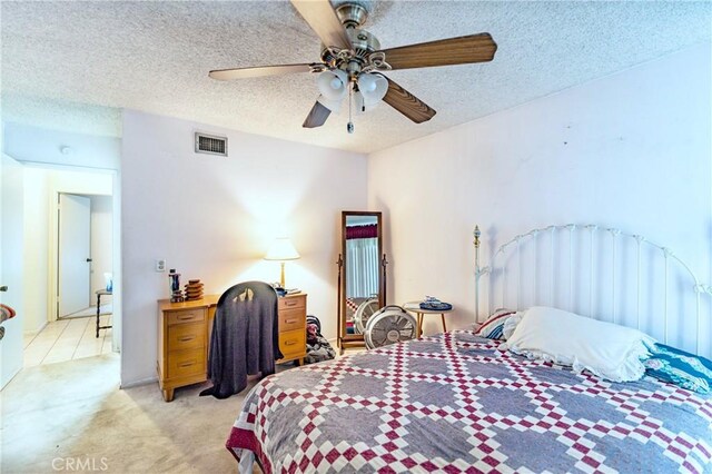 bedroom with light carpet, a ceiling fan, a textured ceiling, and visible vents