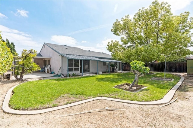 back of house featuring a yard, a patio, and fence