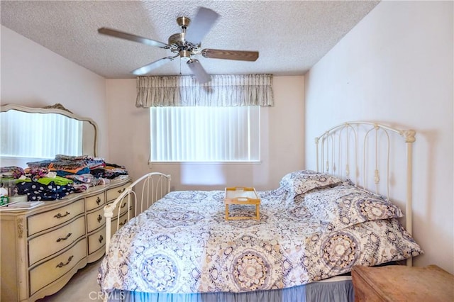 bedroom with a ceiling fan and a textured ceiling