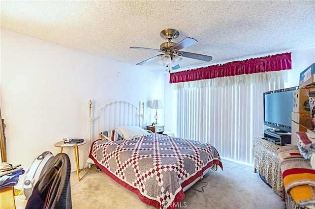 bedroom featuring carpet flooring, a textured ceiling, and a ceiling fan