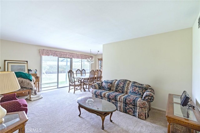carpeted living room featuring a notable chandelier