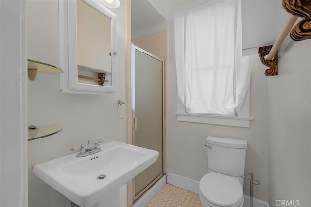 full bathroom with a sink, toilet, tile patterned floors, baseboards, and a shower stall