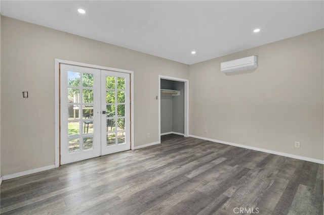 unfurnished bedroom with baseboards, wood finished floors, and a wall mounted air conditioner