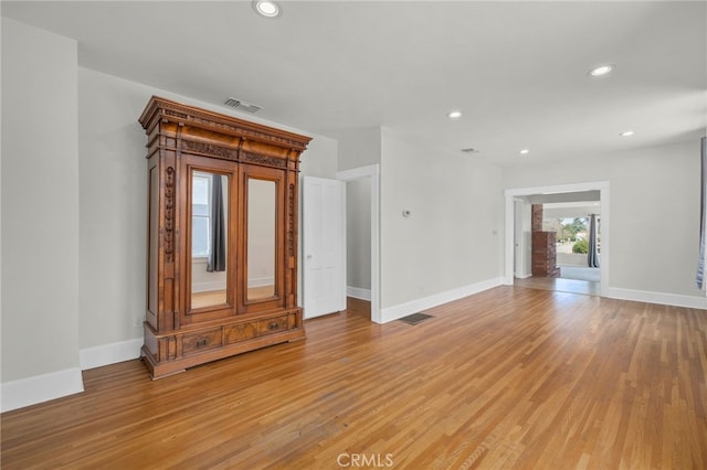 unfurnished living room featuring baseboards, visible vents, and light wood finished floors