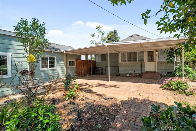 rear view of property featuring crawl space, fence, a shingled roof, and entry steps