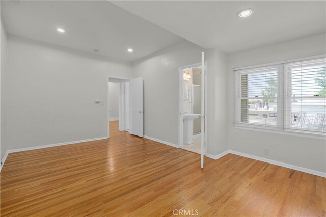 spare room with recessed lighting, baseboards, and light wood finished floors