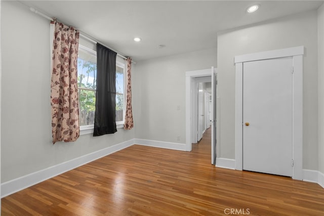 unfurnished room featuring baseboards, recessed lighting, and wood finished floors