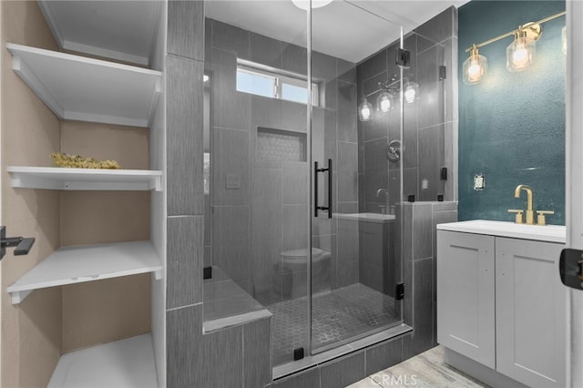 full bathroom featuring wood finished floors, a stall shower, and vanity