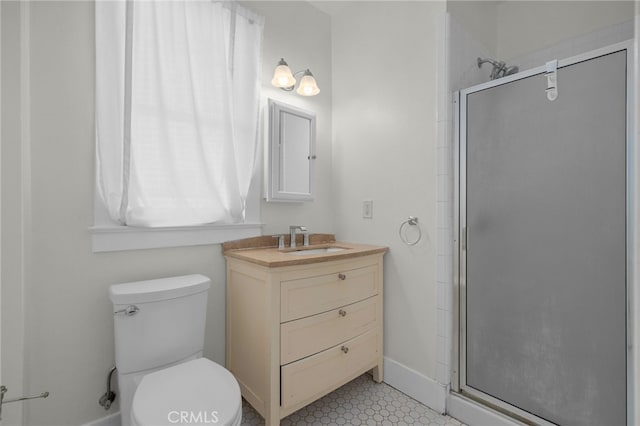 bathroom featuring vanity, baseboards, a stall shower, and toilet