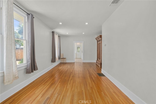 corridor featuring recessed lighting, baseboards, visible vents, and light wood-type flooring