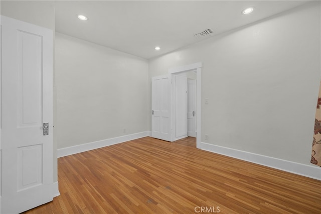 spare room with baseboards, recessed lighting, light wood-style flooring, and visible vents