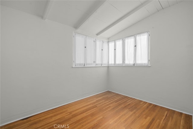 unfurnished room with vaulted ceiling with beams and light wood finished floors