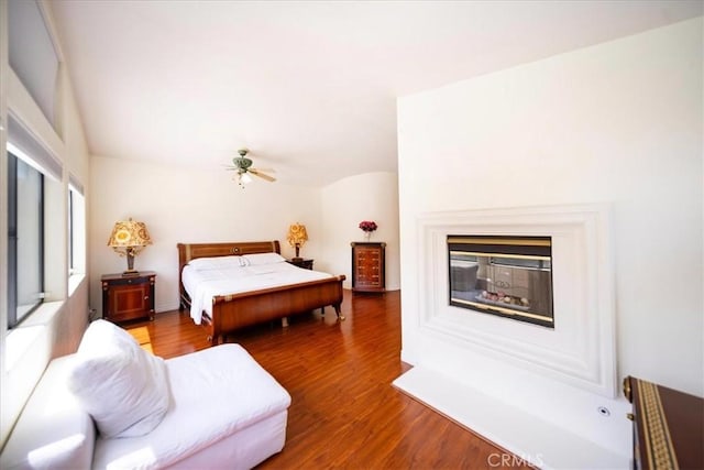 2830 Mount Niguel Cir, Corona, CA 92882 - bedroom with a multi sided fireplace, a ceiling fan, wood finished floors, and lofted ceiling