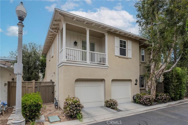27014 Monterey Ave, Valencia, CA 91355 - view of front of home with a garage, a balcony, stucco siding, and driveway