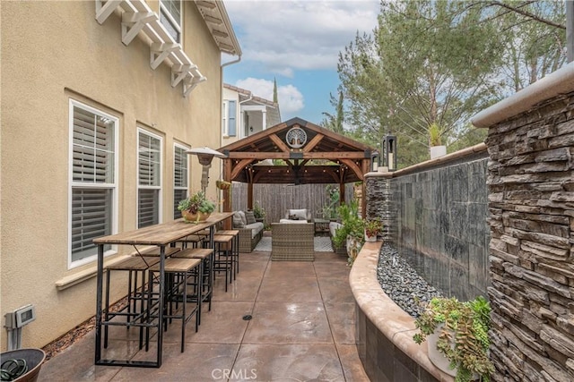 view of patio / terrace featuring an outdoor hangout area, outdoor dry bar, a gazebo, and a fenced backyard