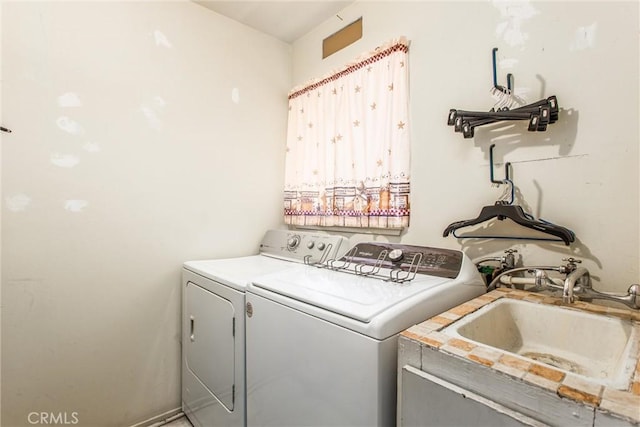 clothes washing area featuring a sink, laundry area, and washing machine and dryer