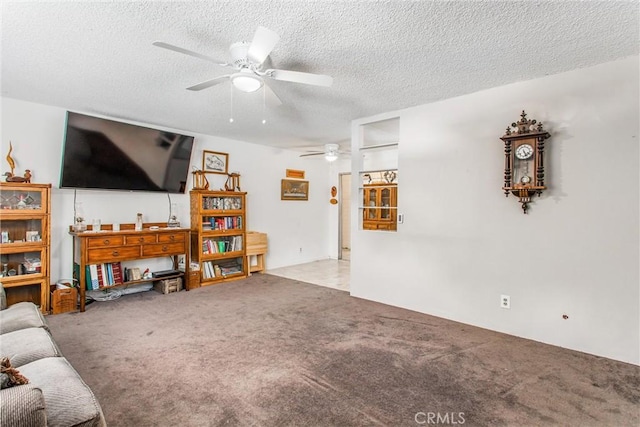living room featuring carpet floors, a ceiling fan, and a textured ceiling