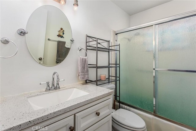 full bathroom with toilet, bath / shower combo with glass door, and vanity