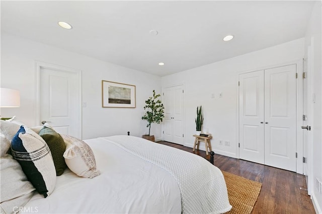 bedroom with recessed lighting, baseboards, two closets, and dark wood-style floors