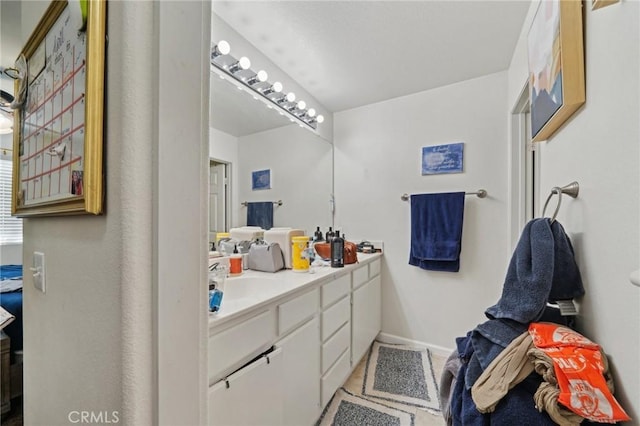 full bath with vanity and baseboards