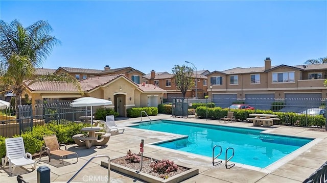 pool featuring a residential view, fence, and a patio
